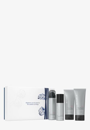 Set aus vier Hautpflegeprodukten in grauen Behältern, darunter Duschschaum, Deodorant und Körperlotion, präsentiert in einer weißen Box mit blauen Akzenten.