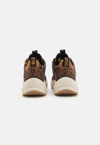 Baskets noires et brunes avec des accents pailletés, col rembourré, forme arrondie et semelle beige robuste. Détails de marque sur le talon.