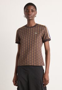 Braun Kurzarm-T-Shirt mit geometrischem Muster, kontrastierendem dunklem Kragen und Bündchen sowie Lacoste-Logo auf der Brust.