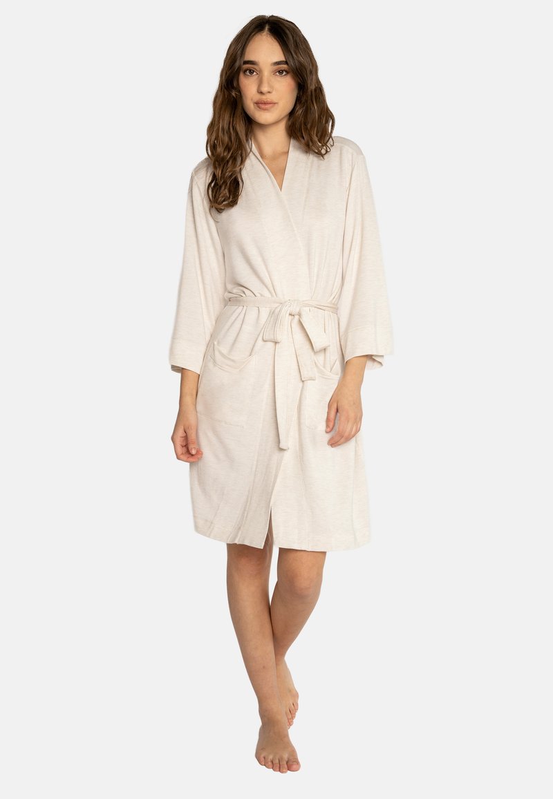 Robe di colore beige chiaro, lunga fino al ginocchio, realizzata in un tessuto morbido. Presenta un design avvolgente, chiusura con cravatta e due tasche frontali. Maniche lunghe con una vestibilità comoda.