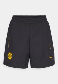 Sorte atletiske shorts med elastisk talje, sidelommer, gult BVB-logo og Puma-logo, der har en glat tekstur og let design.