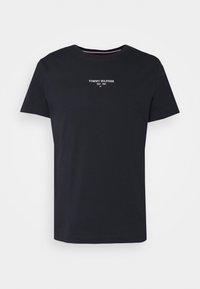 Námořnická modrá bavlněná tričko s krátkým rukávem, kulatým výstřihem a bílým nápisem "TOMMY HILFIGER EST. 1985" na hrudi. Jednoduchý design, bez vzorů.