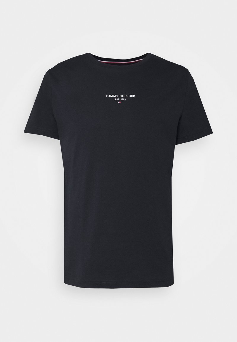 Námořnická modrá bavlněná tričko s krátkým rukávem, kulatým výstřihem a bílým nápisem "TOMMY HILFIGER EST. 1985" na hrudi. Jednoduchý design, bez vzorů.