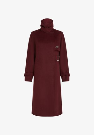 Burgundia villasegu segu jakk, millel on kõrge krae, asymmeetriline kinnis ja metallist luku detail. Omab pikki varrukaid, millel on rullitud äärised.