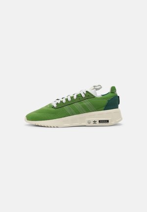 Grüner Low-Top-Sneaker mit weißen Schnürsenkeln und Sohle, mit Adidas-Streifen und Primeblue umweltfreundlichem Label an der Seite.
