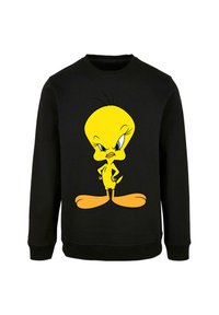 Felpa nera con una grande grafica di un uccello cartone animato giallo con occhi blu prominenti, in piedi con le mani sui fianchi.