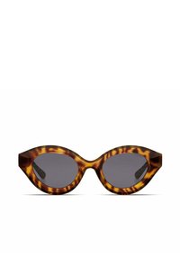 Occhiali da sole cat-eye in tartaruga con lenti scure, caratterizzati da una montatura spessa e punte leggermente appuntite alle tempie.