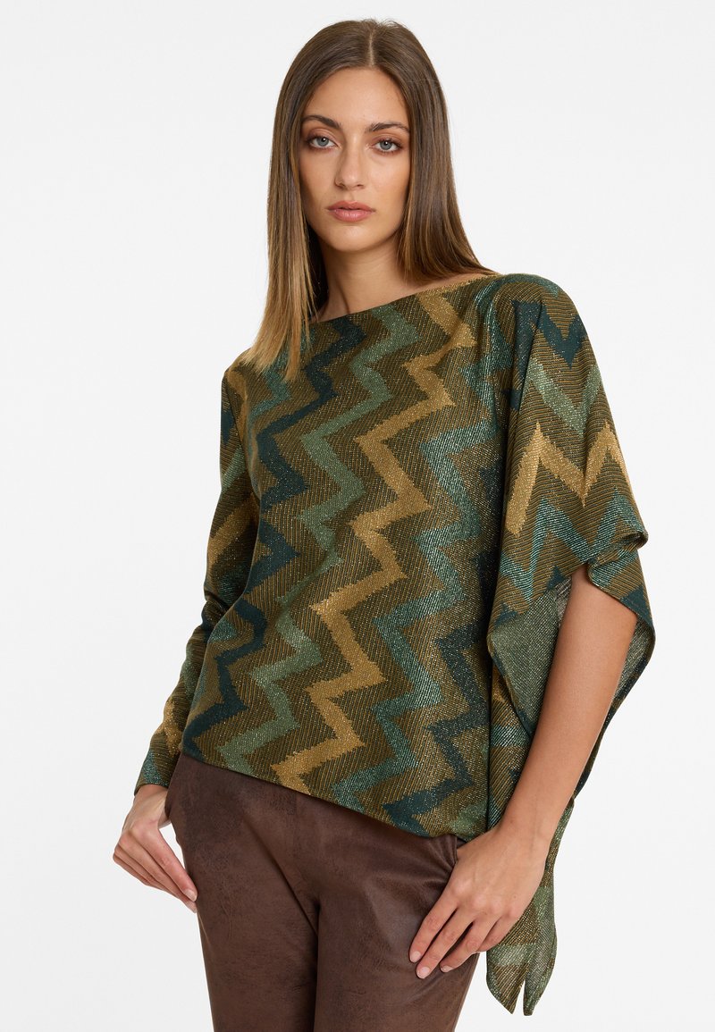 Poncho en bronze et vert à motifs zigzag, avec un large col et une coupe ample, fabriqué à partir d'un tissu métallisé doux et texturé.