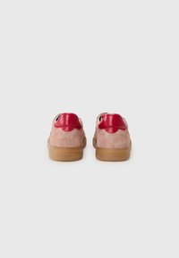 Sneaker classiche con una tomaia in suede rosa e dettagli in pelle rossa, dotate di suola in gomma e design della punta arrotondato.
