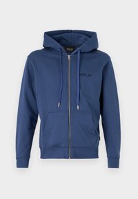 Marineblå zip-up hoodie med en frontlomme, snoretræk i hætten, ribbede manchetter og et diskret broderet logo på brystet. Blødt materiale.