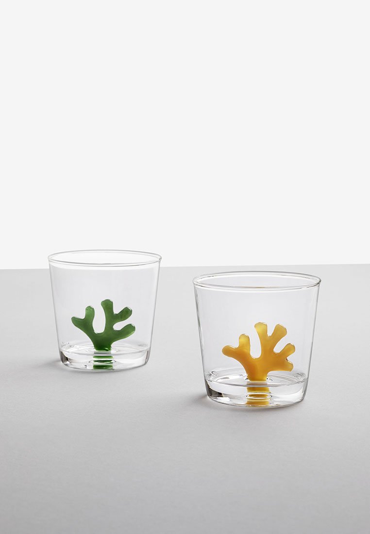 Przezroczyste szklanki z podstawami w kształcie koralowców; jedna jest zielona, a druga żółta. Gładka faktura, nowoczesny design, odpowiednie do różnych napojów.