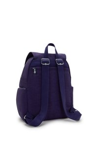 Lila tygryggsäck med justerbara axelremmar, handtag på toppen, sidofickor och en dragkedjeficka på bakpanelen.