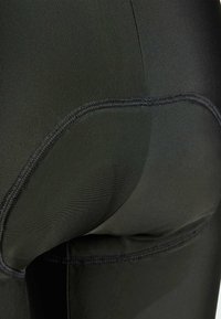 Schwarze Sportleggings mit glatter Textur, enganliegendem Design und sichtbaren Nähten auf der Rückseite für verbesserte Struktur.