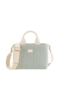 Sac à main matelassé vert clair avec poignées crème et bandoulière crème réglable, avec une petite plaque de marque dorée à l'avant.