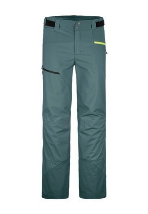 Teal waterproof pants with a modular design, featuring zippered pockets, contrasting black and yellow accents, and reinforced knees.