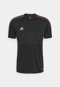 Svart idrottströja med horisontell färgblockering med regnbågsfärgade ränder på axlarna och Adidas-logotyp i regnbågsfärger på bröstet.