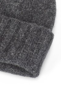 Berretto lavorato a maglia grigio realizzato in lana spessa e morbida con un design a costine. La texture appare pelosa, mostrando diverse tonalità di grigio.