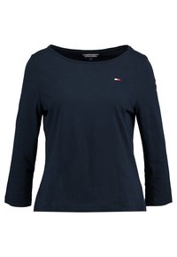 Námořnický modrý dlouhý rukáv top vyrobený z bavlny, s širokým výstřihem a malým tri-color logem na hrudi. Hladká textura.