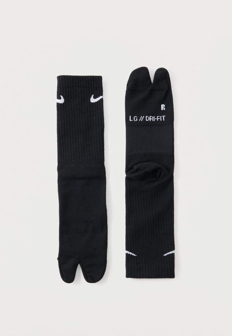 Ζευγάρι μαύρες κάλτσες Nike tabi με χωριστά δάχτυλα, με λευκά λογότυπα swoosh και το κείμενο «LG // DRI-FIT» σε μία κάλτσα.