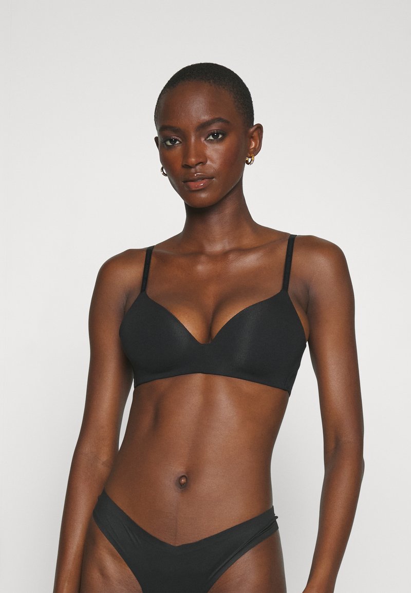 Black bra with a seamless, ribbed design, plunge neckline, and adjustable straps, paired with matching black bikini bottom.