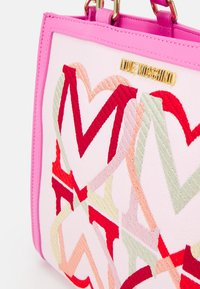Růžová kabelka s vyšitými překrývajícími se srdci v červené, růžové, béžové a zlaté barvě, s logem "Love Moschino" na horním předním panelu.