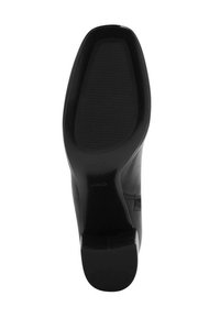 Chaussure à talons hauts noire avec une tige en cuir lisse et une semelle en caoutchouc texturée. Le talon est de hauteur modérée et présente un design épuré.