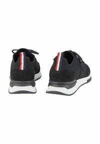 Schwarze Sneaker aus Mesh- und Wildledermaterialien mit einer weißen Sohle und einem rot, weiß und blau gestreiften Akzent auf der Rückseite.