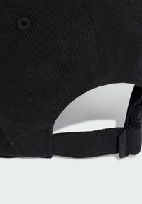 Czarna czapka bejsbolowa z teksturowanym materiałem sztruksowym. Posiada wygiętą wizjer, regulowany pasek oraz plastikowy zapięcie z tyłu.