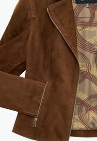 Bordeaux suède jasje met een ritssluiting aan de voorkant, schuin geplaatste zakken en een gemusterde binnenvoering in goud en bordeauxrood. Soepele textuur met een op maat gemaakt design.