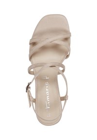 Beige strappy sandal with a square toe design, featuring crossed straps and a rear ankle buckle. Suede-like texture and cushioned insole.