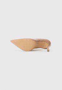 Décolleté in pelle lucida color nude con tacco stiletto sottile. La suola presenta un motivo testurizzato. Finitura liscia con un aspetto lucido.