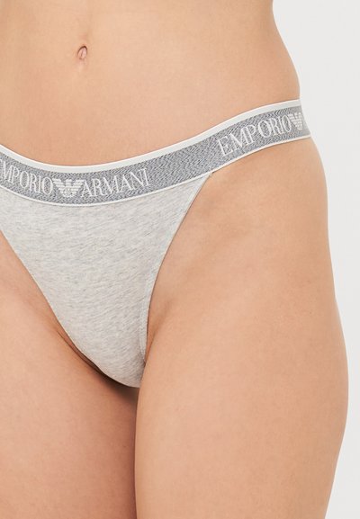 Halli puuvillased string aluspüksid pehme vöökaarega, millel on valge "Emporio Armani" logo. Sile tekstuur ja minimalistlik disain.