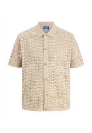 Beige rövid ujjú gombos ing, amely textúrált cikk-cakk mintázattal és klasszikus gallérral rendelkezik. Könnyű kötött anyag, öt gombbal.