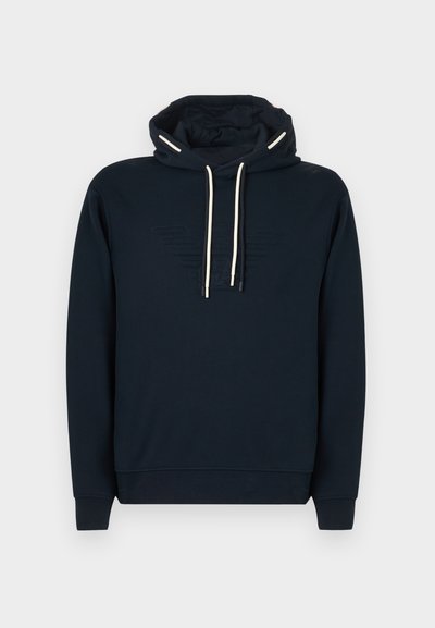 Μπλε ναυτικό φούτερ με μπροστινή τσέπη καγκουρό, λευκά κορδόνια, ανάγλυφο λογότυπο στο στήθος, ριμπ μανσέτες και τελείωμα.