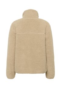 Veste en polaire beige avec un col montant, surface texturée et coupe décontractée. Comprend une couture horizontale dans le dos pour un style supplémentaire.