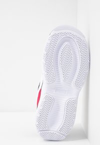 Semelle blanche de chaussure Puma avec motifs ondulés et logo Puma au centre, présentée sur un fond blanc avec des coins.