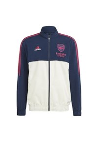 Námořnická a bílá zipová bunda s polo límcem, logo Adidas a erb Arsenalu. Obsahuje růžové akcenty a elastické manžety. Hladký povrch.