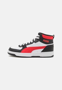 High-top sneaker featuring white leather, black and red accents, textured surfaces, and a white sole. Logo on heel with lacing front.