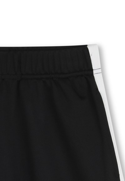 Shorts de sport noirs avec taille élastique, bandes latérales blanches et tissu texturé avec un motif en mesh respirant.