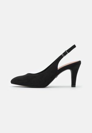 Salón slingback de ante negro con punta puntiaguda, correa ajustable en el tobillo y tacón de aguja de altura media sobre fondo blanco.