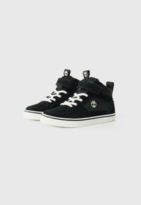 Svart semsket høy-top sneakers med hvite snøring, borrelås, og en hvit gummisåle. Har en liten logo på siden.