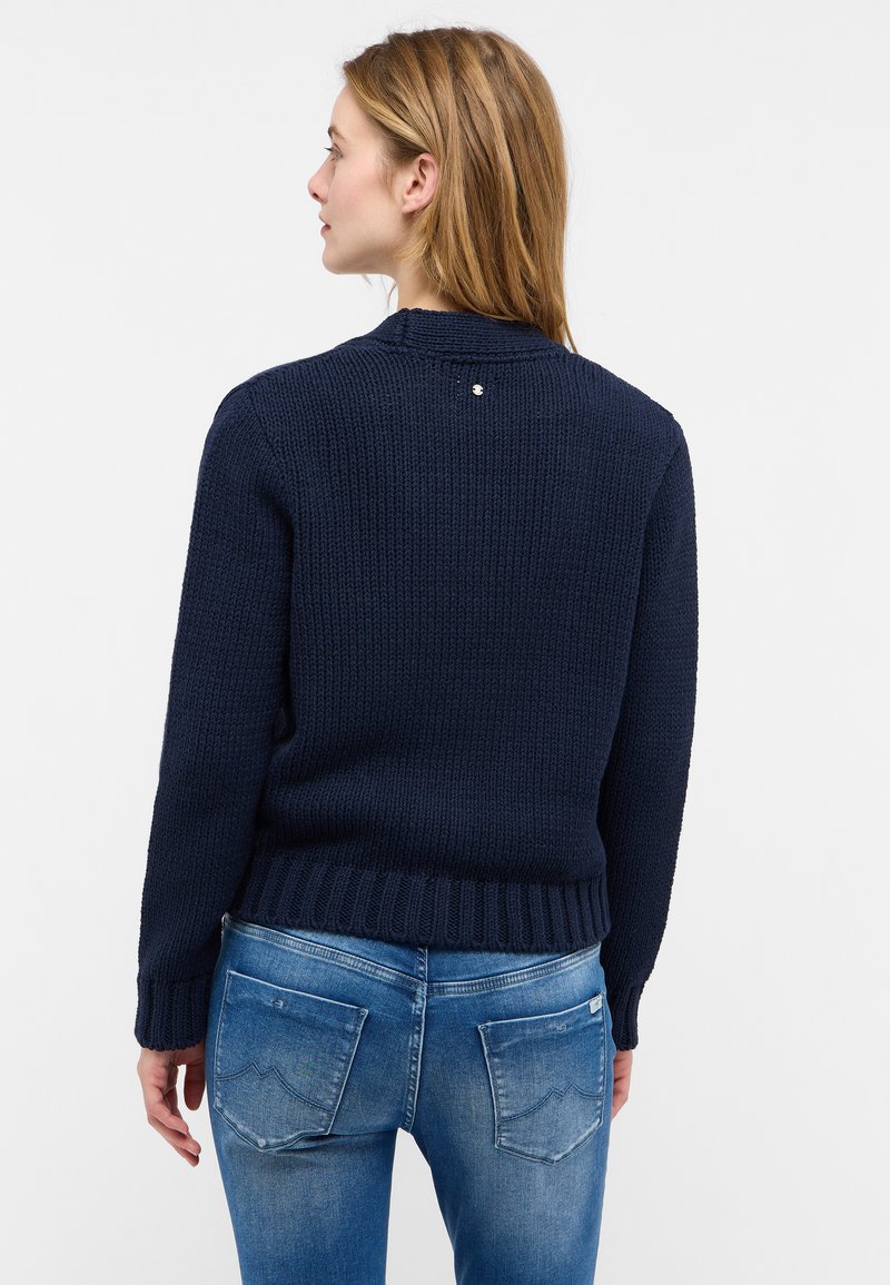 Dunkelblauer Strickpullover mit Rundhalsausschnitt, strukturiertem Stoff, gerippten Bündchen und Saum, mit einem kleinen metallischen Akzent auf der Rückseite.