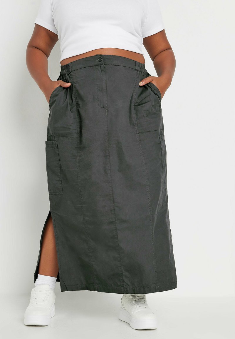 Mustapitu maxi-hame, jossa on nappi ja joustavyötärö, sivutaskut ja reiden yli ulottuva halkio. Yhdistetty valkoiseen crop-toppiin ja valkoisiin lenkkareihin.