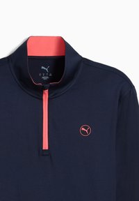Marineblauer Langarm-Pullover mit zip-kragen, versehen mit einem korallenfarbenen Kragen und Reißverschluss sowie einem rosa Puma-Logo auf der Brust.
