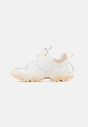 Witte chunky sneaker met beige zool, zwart-witte veters, mesh-details en treklusjes bij de hiel en tong, op een effen achtergrond.