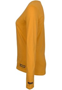 Långärmad t-shirt med rund halsringning i senapsgul. Gjord av mjuk bomull, har rak skärning, sidsömmar och logotag nära fållen.