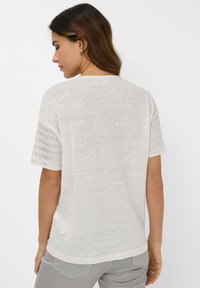 Witte, gestructureerde top met korte mouwen en een ronde hals, met gestreepte accenten op de mouwen. Casual, licht losse pasvorm, geschikt voor warm weer.