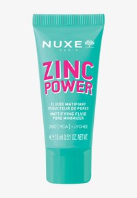 Tealfärgad plasttub med en vit och stark rosa etikett. Produktnamnet "Zinc Power" visas tydligt. Innehåller 15 ml mattande fluid.