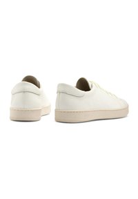 Sneaker bianche in pelle con finitura texturizzata, suole in gomma crema e design minimalista. Dotate di chiusura con lacci e colletto imbottito.