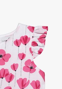 Blumenmusterkleid mit einem weißen Stoff und rosa Blumenmustern, mit Rüschenärmeln und schwarzen gestrichelten Linien, die die Blüten verbinden.